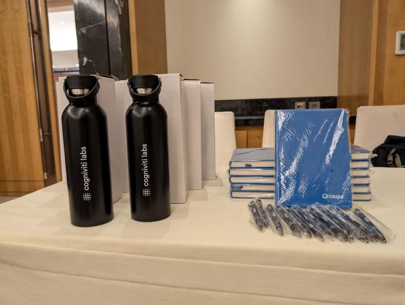 Cogniviti Labs bottles and Coupa notebooks laid out for an event